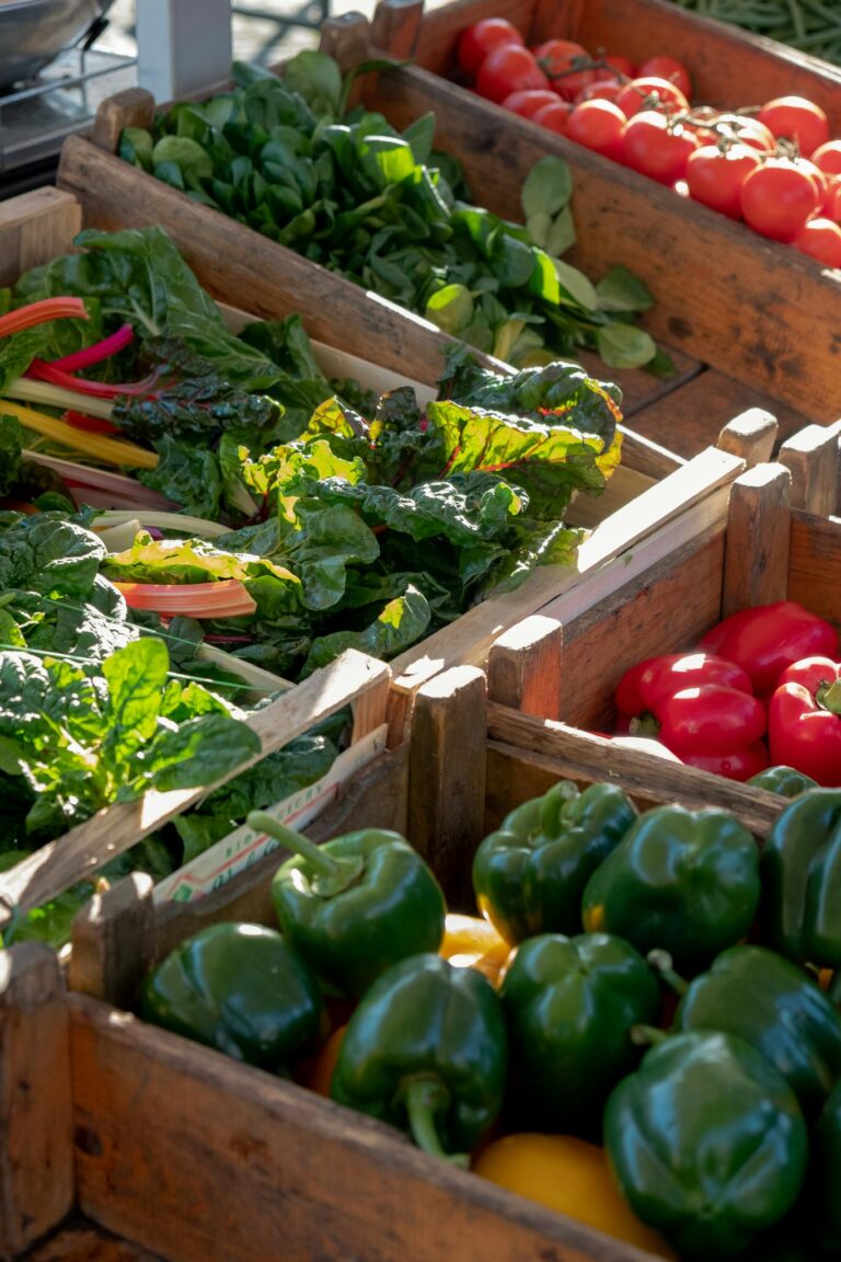 Vibrant display of fresh vegetables including peppers and tomatoes at a farmer's market.